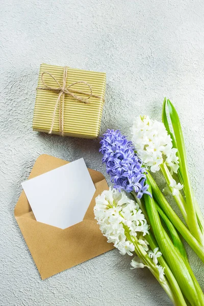 Mother's day Holiday Concept. Hyacinth, flowers and empty card on shabby wooden background. Greeting card for Womens or Mothers Day. Flat lay, top view, copy space. Mockup concept.