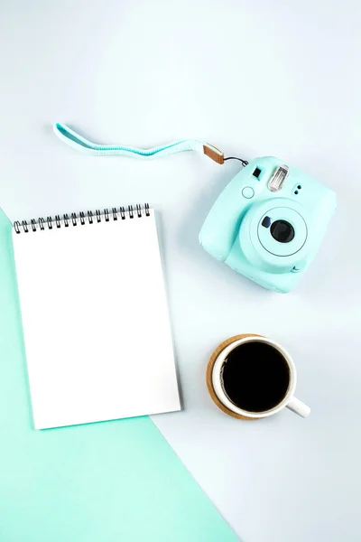 Flat lay com mini câmera moderna, caderno vazio e xícara de coff — Fotografia de Stock