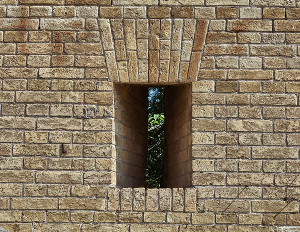 要塞が付いている小さい抜け穴のレンガの壁の断片 — ストック写真