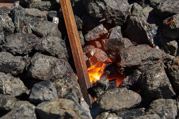 La billetta in metallo viene riscaldata in carboni ardenti — Foto Stock