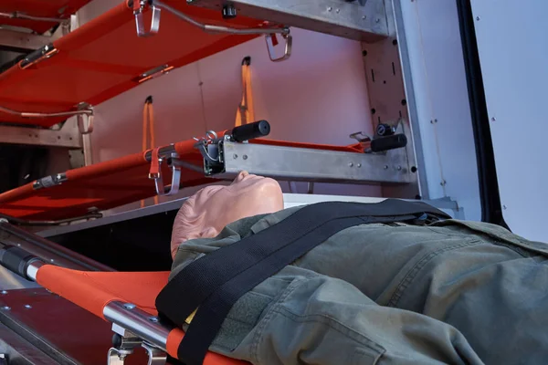 戦場から負傷者を避難させるための医療機器の背景にストレッチャー上の軍の制服を着たマネキン — ストック写真