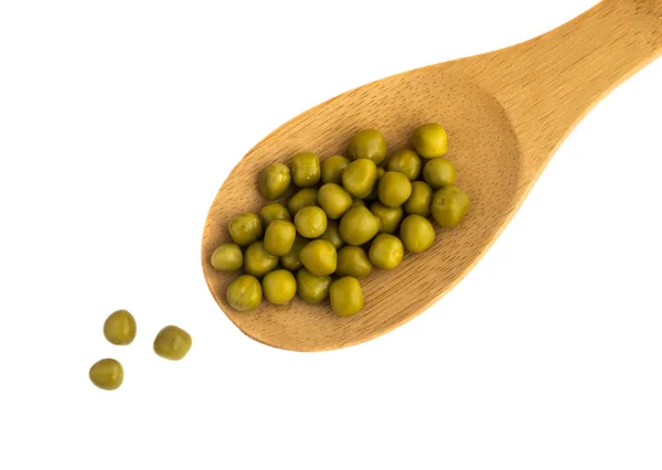 Cucchiaio di legno con piselli in scatola verde isolato su sfondo bianco — Foto Stock