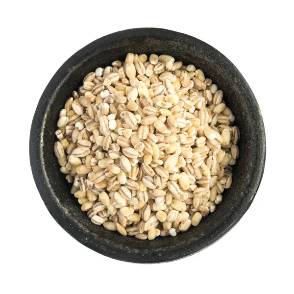 Raw Dry Pearl Barley Grains Heap in ciotola di ferro nero Foto Stock Royalty Free