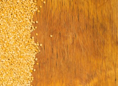 Kuru bölünmüş eski ahşap kesme tahtası üzerinde dağınık sarı bezelye