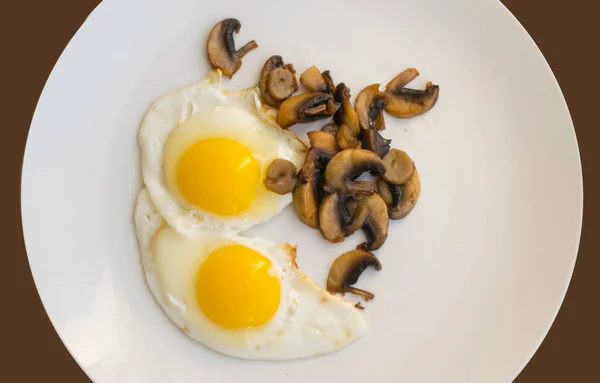 Stekta ekologiska ägg med svamp på en vit platta — Stockfoto
