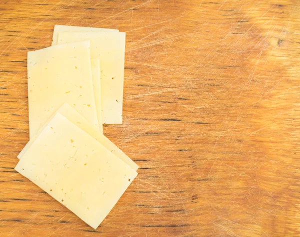 素朴な木製の背景の上にチーズをスライス — ストック写真