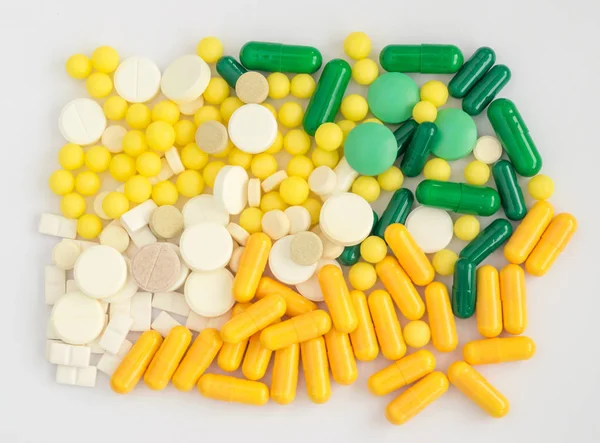 Cápsulas, comprimidos e comprimidos médicos em um fundo leve — Fotografia de Stock