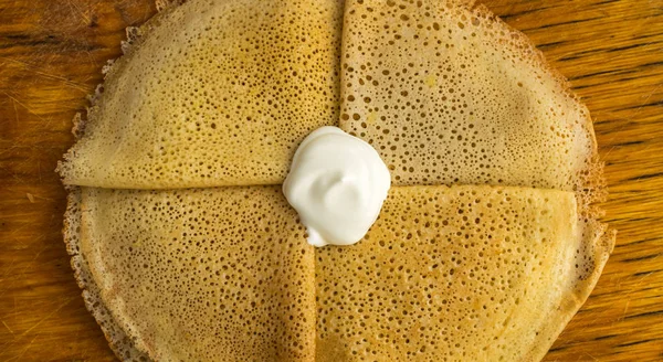 Dünne Pfannkuchen auf einem hölzernen Hintergrund Draufsicht — Stockfoto