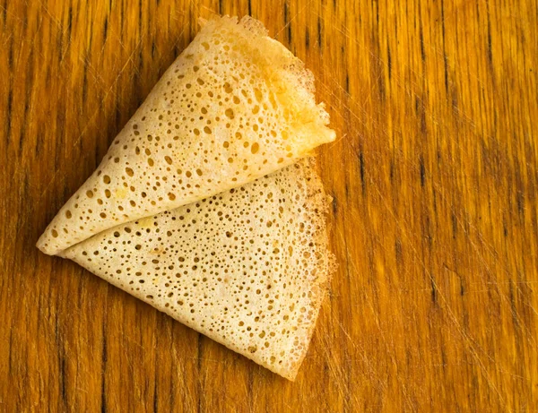 Dünne Pfannkuchen auf einem hölzernen Hintergrund Draufsicht — Stockfoto