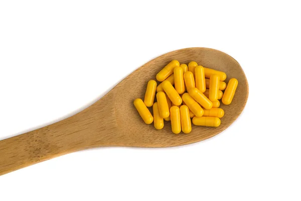 Píldoras de medicina farmacéutica en cuchara de madera — Foto de Stock