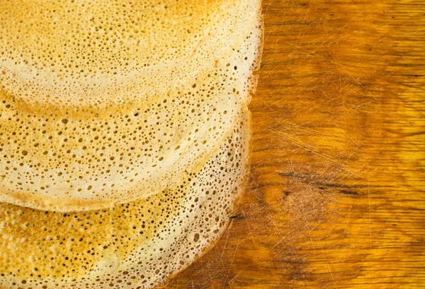 Dünne Pfannkuchen auf einem hölzernen Hintergrund Draufsicht. frische hausgemachte Crêpes — Stockfoto