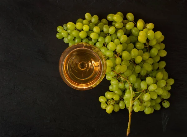 Verre à vin blanc sur fond de raisin vert mûr en journée ensoleillée — Photo
