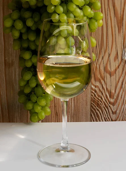 Verre à vin blanc sur fond de raisin vert mûr en journée ensoleillée — Photo