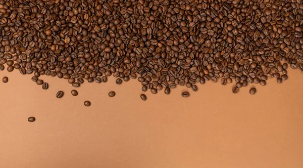 Donkerbruine hele koffiebonen op houten ondergrond met copyspace — Stockfoto
