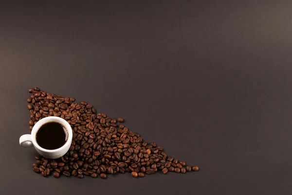 Forró kávé csésze és kávébab fekete háttér felülnézet — Stock Fotó