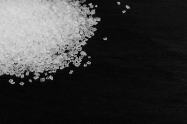 Siyah arka planda büyük şeker kristalleri yakın plan. Sukroz kristalleri, deniz tuzu kayaları ya da seçici bir odak noktası olan yiyecek üzerine sodyum tuz dokusu.