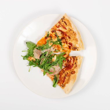 Domatesli, jambonlu, roka peynirli ve mozzarella peynirli geleneksel İtalyan pizzası. Lezzetli İtalyan pizzası. Beyaz tabakta jambon.