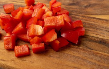 Kırpılmış kırmızı biber ya da ahşap masa arkasında kırmızı biber kesikleri. Kesme tahtasında doğranmış dolma biber