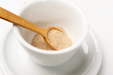 Beyaz fincanda 3 'te 1' lik kahve, hazır çay, kakao ya da beyaz arka planda izole edilmiş çikolata. Açık kahverengi içecek tozu ile kuru süt ve şeker karışımı.