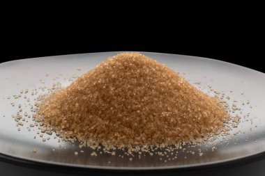 Tahta kasede beyaz arka planda izole edilmiş kahverengi şeker yığını. Rafine edilmemiş şeker yığını yan görünüm