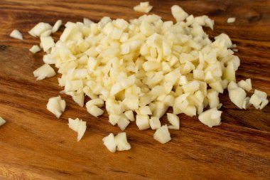 Tahta arka planda taze ezilmiş sarımsak. Yığınla sarımsak ezmesi yakın çekim için.