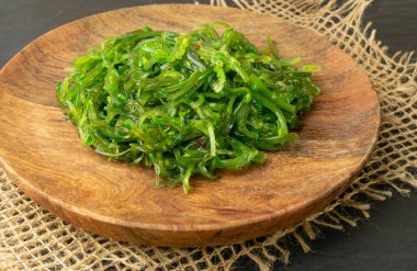 Yeşil Chuka Seaweed Salatası Rustik arka planda. Wakame Deniz Yosun Namazı, Çukka Deniz Otu, Tahta Tabakta Sağlıklı Yosun Yiyecekleri
