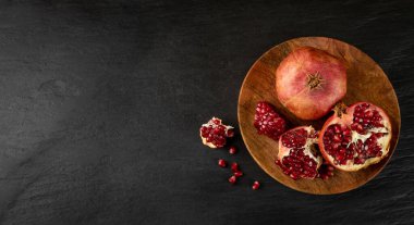 Taze olgun organik nar meyvesi ve sulu tohumlar Rustik plaka üzerinde ve yiyecek arkaplanı fotokopi uzayı ile üst görünümü. Köy Biçiminde Yaşam