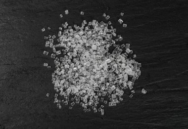 Siyah arka planda büyük şeker kristalleri yakın plan. Sukroz kristalleri, deniz tuzu kayaları ya da yiyecek tabakasında granüle edilmiş sodyum tuz dokusu.