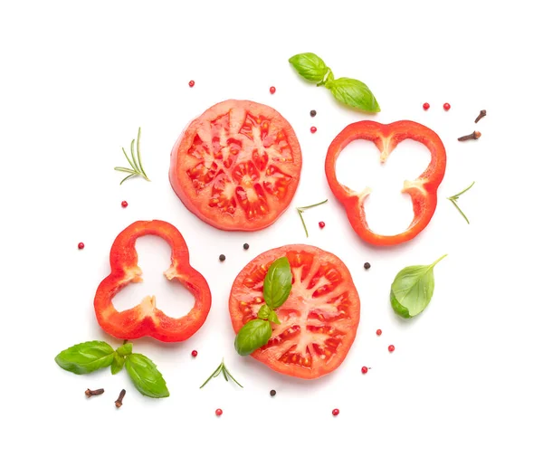 Sliced tomatoes and basil top view and flat lay. Big tomato slices, fresh herbs and spices isolated on white background. Salad ingredients vegetable pattern