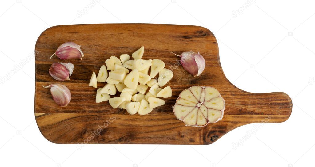 Fresh sliced garlic on wood cutting board background isolated with lipping path. Heap of chopped garlic cloves top view