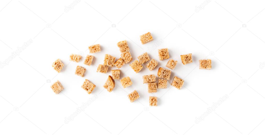 Scattered pile of homemade rye bread croutons isolated on white background top view. Crispy bread cubes, dry rye crumbs, rusks, crouoton or brown roasted crackers cube