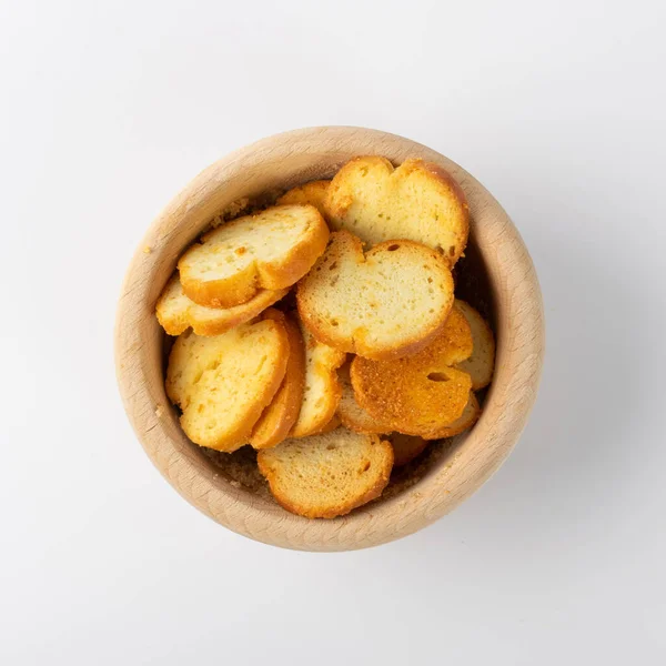Homemade crunchy croutons with garlic, herbs and spices in wood bowl isolated. Round spicy bruschetta crackers, seasoning rusks or small fried bread snacks top view — Stock Image Homemade Crunchy Croutons Garlic Herbs Spices Wood Bowl Isolated Spicy Royalty Free Stock Images