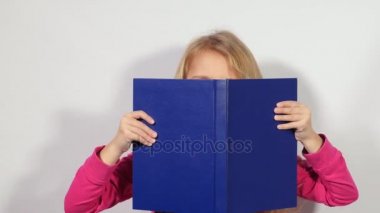 Kitaptan görünüyor. Küçük kız casus büyük kitap. Blondy kız açık bir büyük mavi kitap devam ediyor..