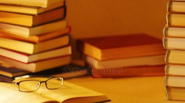 Bir yığın kitap ifade en iyi kitap görünür. Kitap yığınları arka plan üzerinde açık kitap gözlüklü. Stop motion