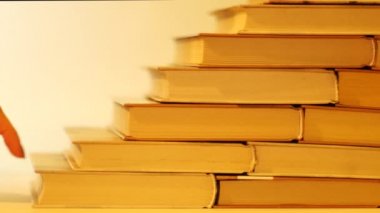 Kitap derme çatma merdivenlerden el hareketi. El kitaplar merdivenlerden yürür. 