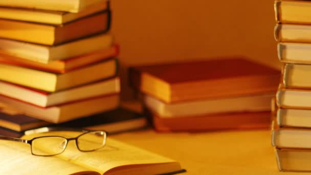 Montones de libros sobre una mesa. Cerca del libro abierto con gafas aparece la inscripción BESTSELLERS. Detener movimiento — Vídeos de Stock