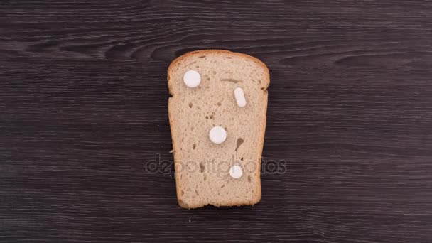 Bir parça ekmek ile hapları. Tost sürekli ilaç kullanıyordu. Üstten Görünüm. Stop motion — Stok video