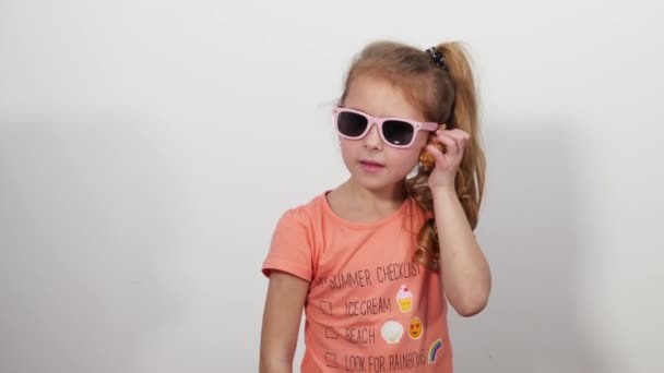 Girl raises shell to ear and makes simulating sea wave of hand. — Stock Video