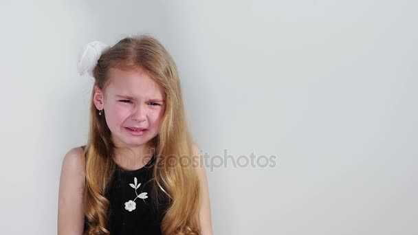 Hermosa niña llorando en vestido negro sobre el fondo blanco . — Vídeos de Stock