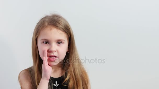 Привлекательная маленькая девочка шепчет в камеру . — стоковое видео