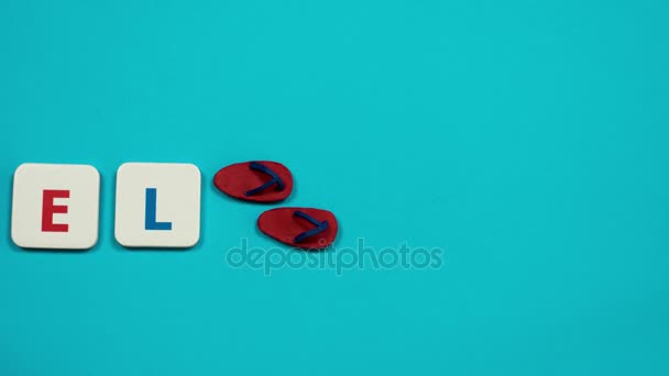 Las chanclas de plastilina roja tiran de la palabra VIAJE hecha de letras rojas y azules. Detener movimiento — Vídeo de stock