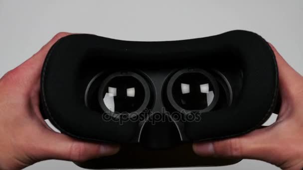 Virtual reality-glasögon går mot en kamera. Simulering av bär Vr Headset på kameran. Närbild bild av att sätta på Vr-glasögon. — Stockvideo