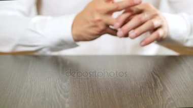 Beyaz gömlekli bir adam bir nişan yüzüğünü çıkar parmağını alır. Boşanma kararı.