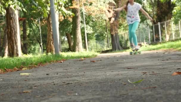 Het meisje op het skateboard duwt een voet en passeert. — Stockvideo