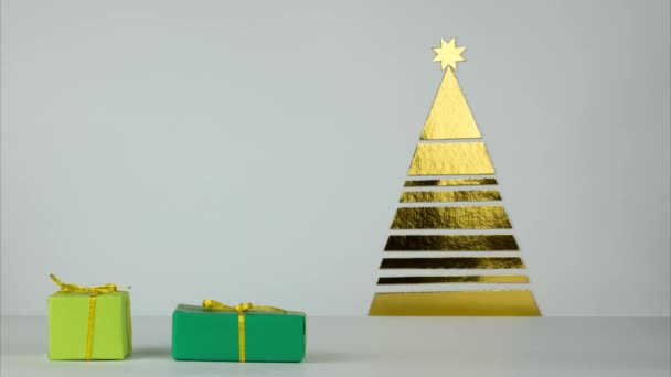 Eine Reihe von Geschenken kommt in den Rahmen und wird unter den Baum gelegt. Weihnachtsgeschenke unter dem Baum in goldgrüner Farbe. Stop-Motion — Stockvideo