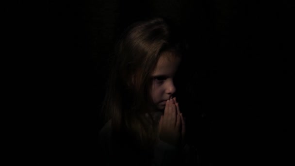 Beau visage de petite fille priant sincèrement la nuit . 