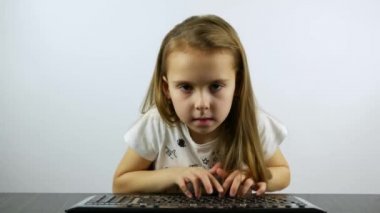 Yoğunlaşmış bir kız klavyenin düğmesine kuvvetlice basar ve zaferle sevinir.