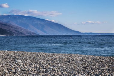 Mavi deniz, çakıl taşı plajı.