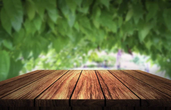 wooden table in front of green leaf in garden background of day lights
