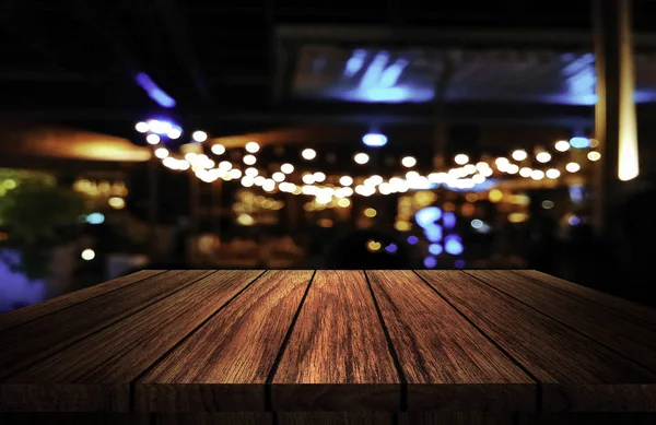 Arka arka plan bulanık Restaurant ışıkların önünde ahşap masa — Stok fotoğraf